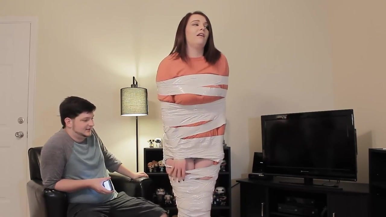 Duct tape mummy girl struggles through apartment.